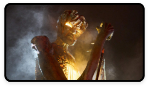 A wooden statue of a creature with illuminated eyes is erected for the Puca festival.