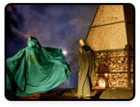 A group of cloaked people stand by a pyramid-like structure for the Samhain Festival in Longford.