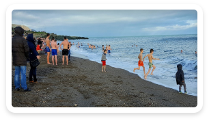 People running in the ocean as part of an ice plunge