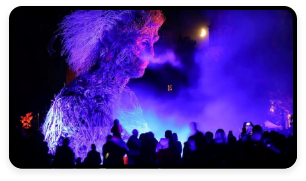 A wooden statue is illuminated in the night for the Macnas street parade in Galway City.